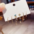 Close-up of a six-piece gold earring set featuring stars and blue cubic zirconia stones - Blue Stone Star Stud Hoop Set