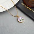 Collar dorado con colgante de flor en esmalte lila y perla central en plato blanco - Púrpura