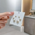 Detailed close-up of golden butterfly earring set with sparkling white zircon stones - Group Butterfly Rhinestone Set