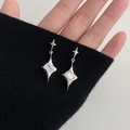 Irreguläre Sternohrringe mit Zirkon im silbernen Design auf Handmodell gezeigt - Unregelmäßiger Sternenstrahl-Stil / Silber