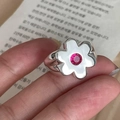 Detailaufnahme eines silbernen Blumenrings mit weißen Blüten und rosa Schmuckstein - Stil Mit Rosafarbenen Zirkonia-Blüten