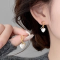 Elegante goldene Knotenohrringe mit schillernden weißen Herzanhängern aus Perlmutt für Damen - Cremeweißes Herz-Stil