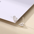 Macro shot of minimalist S925 sterling silver heart stud earring with polished surface - Silver