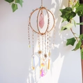 Handmade golden suncatcher with rose quartz pillar and crystal prisms reflecting rainbow light - Rose Quartz