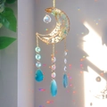 Detail of moon suncatcher with crystals reflecting vibrant rainbow patterns on a wall - Amazonite Style