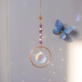 Detail of crystal suncatcher with purple stones and prism casting rainbow light on wall - Amethyst