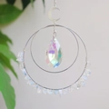 Detailed view of crescent moon crystal hanger with opal stones and iridescent pear pendant - Opal