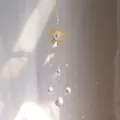Macro detail of sun catcher showing golden sun metal plate and crystal balls reflecting rainbows - Sun and Clear Prism Ball Style (A24)