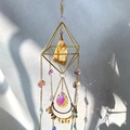 Detail of hanging suncatcher with gold rhombus frame, citrine stone and crystal droplets - Topaz