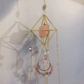 Detail of bohemian suncatcher with pink raw stone and geometric gold metal frame - Salt