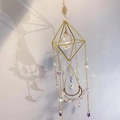 Close-up of geometric crystal suncatcher with natural quartz and golden celestial charms - White Crystal
