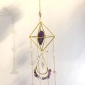 Close-up of diamond-shaped suncatcher with natural amethyst and gold geometric frame - Dark Amethyst