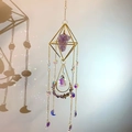 Macro shot of geometric suncatcher casting rainbow prism reflections on a white wall - Light Amethyst