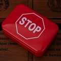 Red tin storage box featuring a white STOP sign on a vintage wooden background - Red STOP Sign Design
