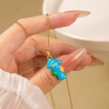 Collier en titane doré avec un joli pendentif dinosaure en émail bleu et détails colorés - Collier Hippocampe Bleu
