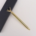 Détail d'un stylo bille en métal doré orné d'un cristal noir brut fixé par quatre griffes - Obsidienne
