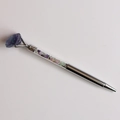 Détail d'un stylo à bille argenté avec des pierres concassées et une pointe en cristal violet - Fluorite