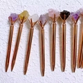 Detailopname van roségouden pennen met verschillende natuurlijke kristalstenen - Rozenkwarts