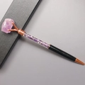 Dettaglio della penna a sfera in oro rosa con cristalli di ametista viola e confezione - Ametista