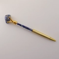 Dettaglio penna a sfera dorata con cristallo blu grezzo e scaglie di pietre naturali - Lapislazzuli
