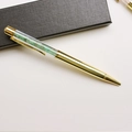 Detailed macro of golden metal pen with green crystal gravel inside a premium gift box - Aventurine Jade / 14.5cm