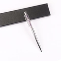 Silver ballpoint pen with purple crystals in window on a textured black gift box - Amethyst