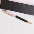 Detail of pink crystal ballpoint pen with gold accents and a black gift box packaging - Rose Quartz