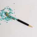 Macro-opname van kristallen balpen met turquoise stenen en gouden metalen accenten - Turkoois