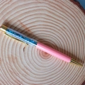 Detail of pink ballpoint pen with gold accents and blue crystal stone filling - Apatite