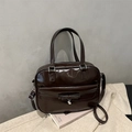 Detail der dunkelbraunen Ledertasche mit Schleifentasche und silbernem Herzanhänger - Dunkelbraun