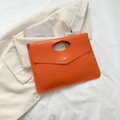 Pochette a busta arancione texture pietra con bottone dorato e manico su blazer beige - Arancione