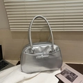 Detail of silver metallic handbag with a decorative bow in a modern lifestyle setting - Silver