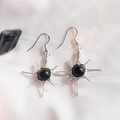 Macro shot of handmade wire wrapped sun earrings with black gemstone and silver hooks - Obsidian