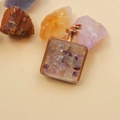 Macro shot of square rose gold perfume pendant filled with mixed natural crystal stones - Colorful Fluorite / 29mm