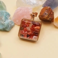Detail of square gold-framed perfume pendant filled with red and orange crystal stones - Red Agate / 29mm