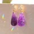 Elegant purple teardrop crystal drop earrings with gold hooks on a white background - Amethyst