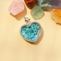 Dettaglio di un ciondolo a forma di cuore con pietre turchesi e cornice argentata - Turchese / 29mm