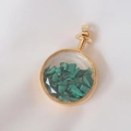 Macro detail of round gold perfume pendant filled with natural green crystal stones - Malachite / 29mm