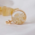Macro shot of circular gold locket filled with natural citrine stones on white silk - Citrine / 29mm