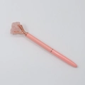 Dettaglio della montatura a griffe in oro rosa con cristallo rosa grezzo sulla penna - Quarzo rosa