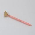 Detail of creative pink crystal ballpoint pen featuring a large yellow raw stone top - Citrine