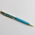 Detail of creative sky blue ballpoint pen filled with turquoise crystals and gold accents - Turquoise
