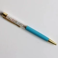 Detail of crystal gravel ballpoint pen with light blue barrel and gold metal accents - Morganite