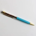 Close-up of blue crystal ballpoint pen with gold accents and tiger eye stone filling - Tiger Eye Stone Bracelet