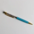 Detail of blue ballpoint pen featuring clear barrel filled with crushed crystals - Labradorite
