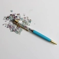 Detail of a blue crystal stone ballpoint pen with gold accents and colorful gemstones - Colorful Fluorite