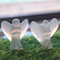 Close-up of two selenite angel figurines with natural vertical textures on green grass - 5-6cm / Selenite Angel Ornament