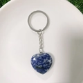 Macro detail of heart-shaped blue natural stone keychain with silver metal ring - Blue Spot Stone