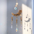 Macro view of crystal crescent moon decor with tiger eye stones and sun charms - Tiger Eye Stone Bracelet