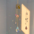 Detailed suncatcher with crystal prism reflecting rainbows from a golden cat silhouette - Cat by the Window